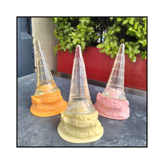 A whimsical acrylic sculpture of a tipped ice cream cone titled “Darnit,” featuring a clear cone standing upright with colourful melting ice cream at its base.