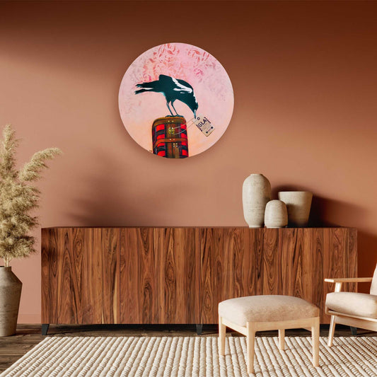 Round acrylic painting of a magpie on a vintage suitcase with pink background – by Mari Moore in lifestyle mockup