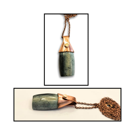 Close-up of handmade greenstone pendant capped with polished copper bail.