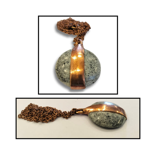Close-up of the unique greenstone pendant wrapped in copper, revealing the subtle stone variations and the warmth of hand-formed metal.