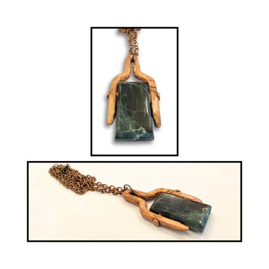 Close-up of greenstone pendant wrapped in copper with large bale, highlighting the natural stone and warm metal textures.