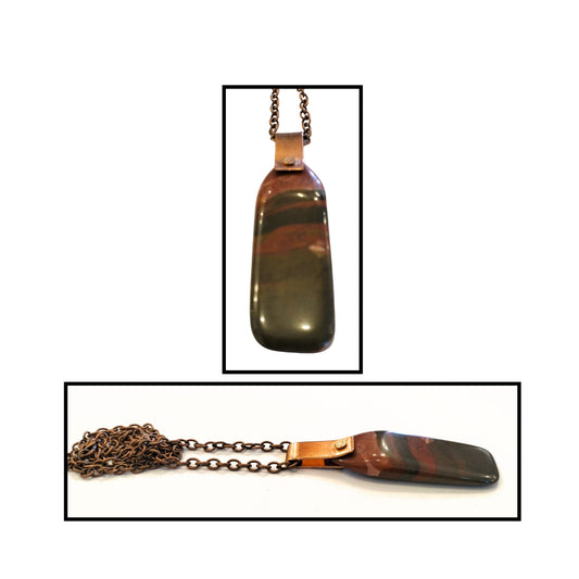 Close-up of natural jasper stone with warm bands and copper detailing.