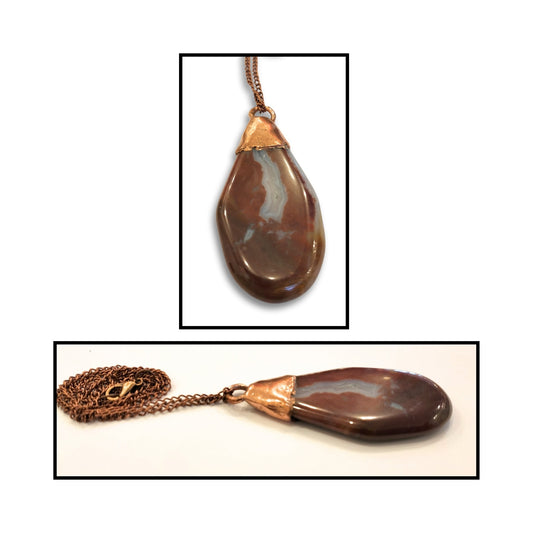 Close-up showing the warm natural layers of the jasper agate and copper bail.