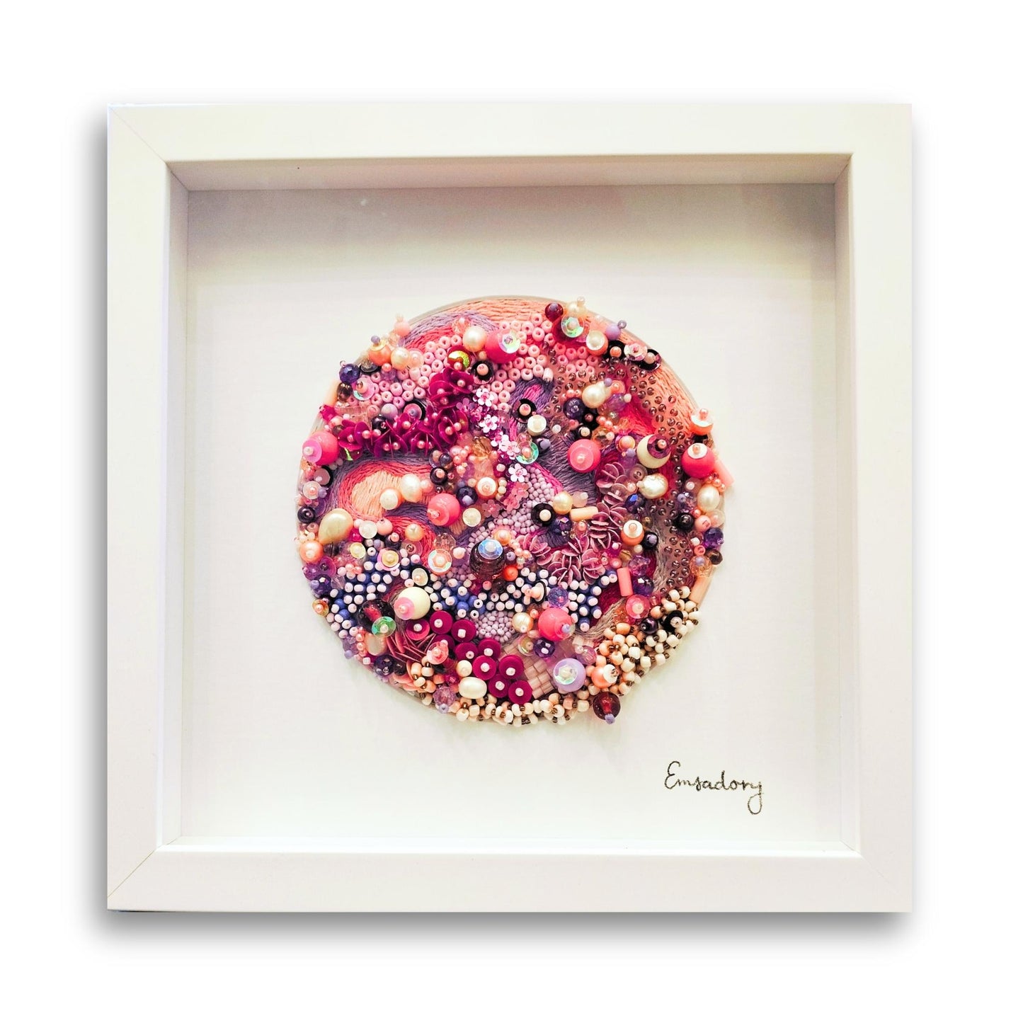 Framed artwork of soft pinks and cream beaded embroidery by artist Emily Richardson on a white background