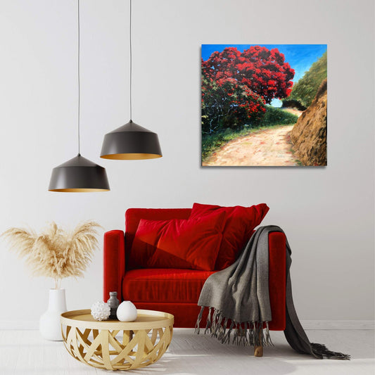 Living room with a red sofa, wooden coffee table, and a painting of a Pohutukawa tree in its red bloom, on the wall.