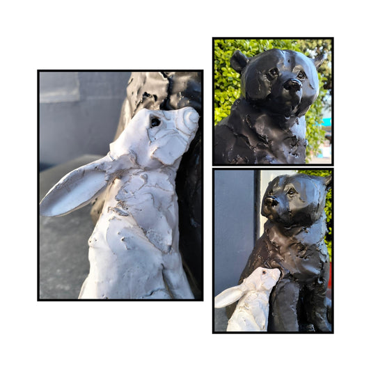 Close up of faces of hand-sculpted ceramic bear and rabbit titled "Secret Crush" by Kylie Matheson – a tender moment captured in clay