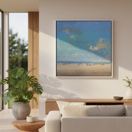 Warm Soft Sand, original oil on board by Nicholas Hayter, expansive beach scene with textured blue sky and tiny figures on sand, white box frame in home setting