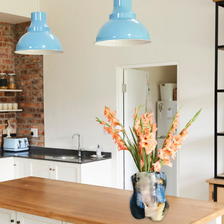Ceramic vase shaped as a torso with blooms sitting on a kitchen counter