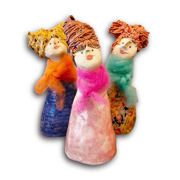 Three colourful ceramic ladies by artist Mandy Olson on white background