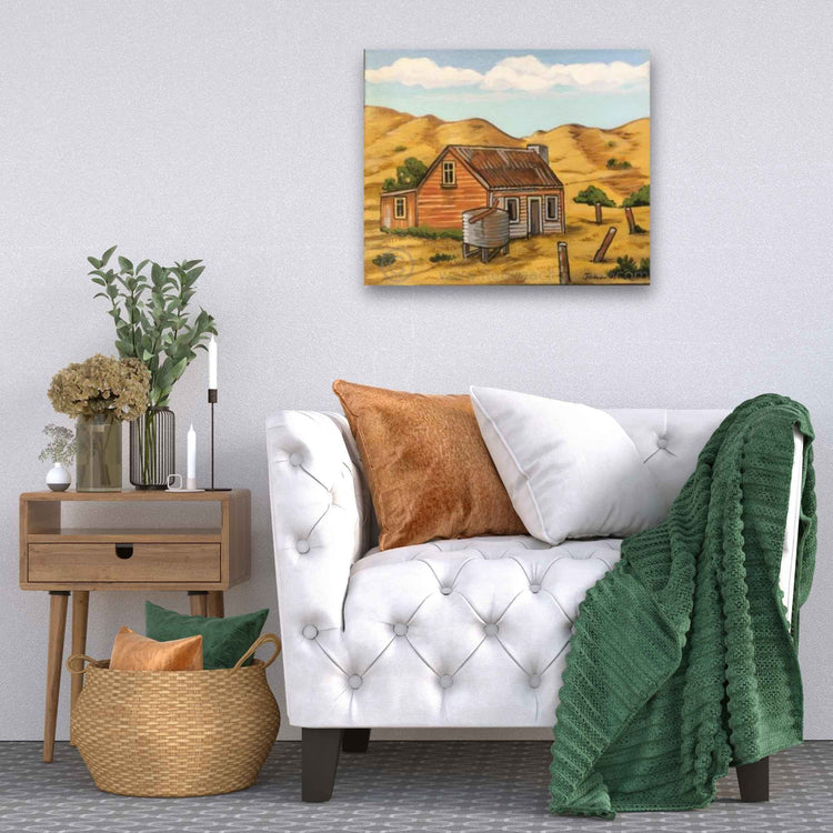 Home setting with a seat, side table and painting "Water Tank" on the wall, artist John Staniford
