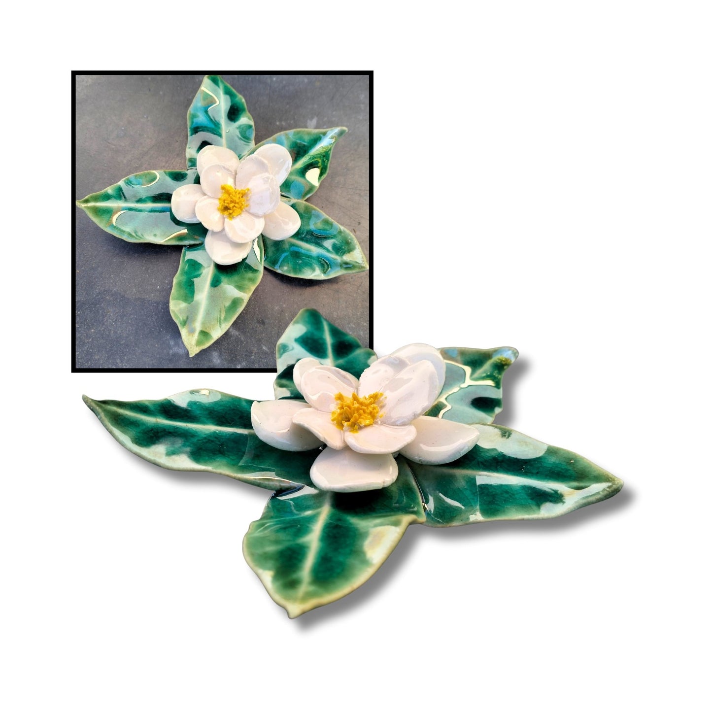 White camellia ceramic wall piece on green sculpted leaf base, glossy finish.

