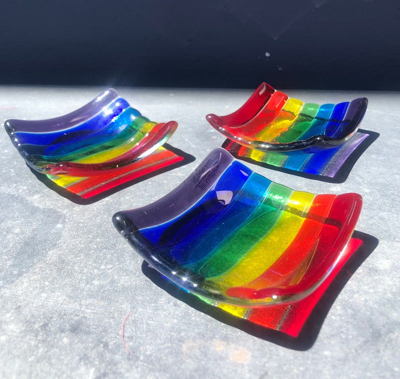 Handcrafted glass trinket dishes with vibrant rainbow stripes in curved rectangular shape