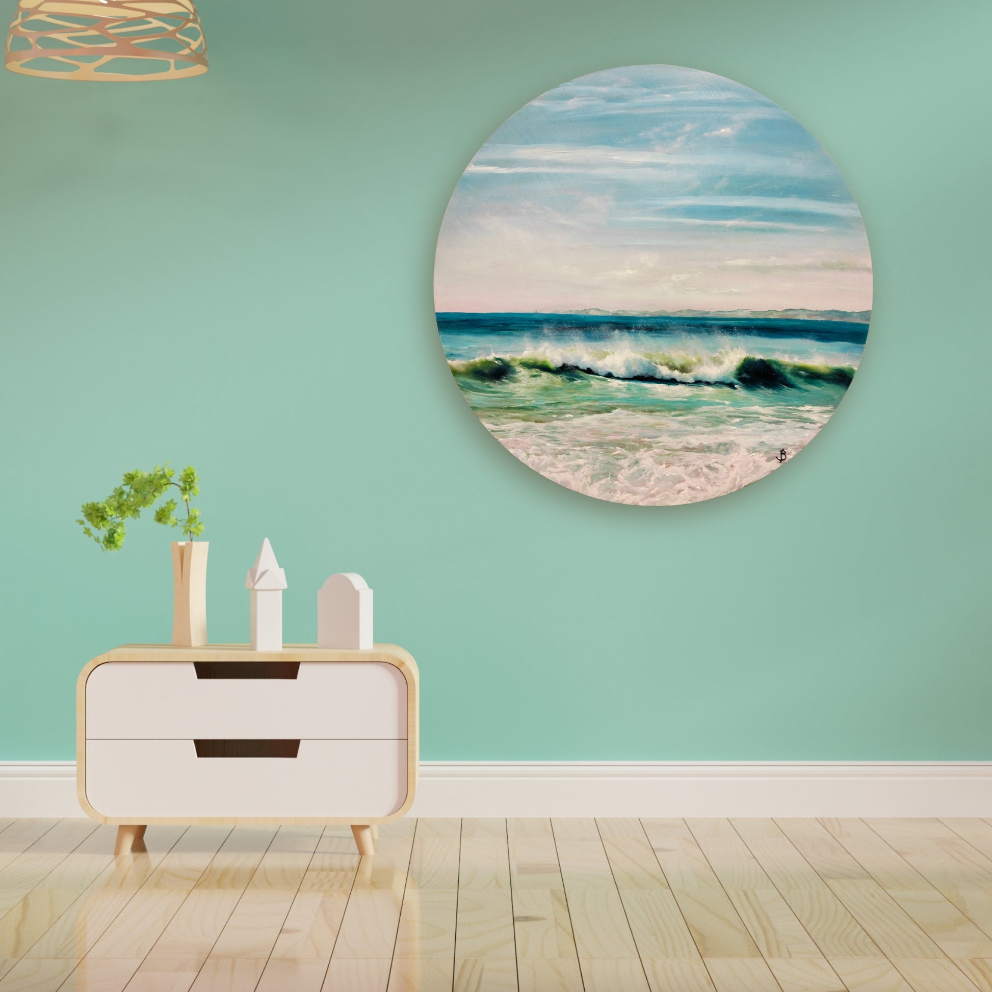 ocean painting on a round board in soft aqua and blue tones  by Bari Duncan, displayed in a lifestyle mockup, lounge setting