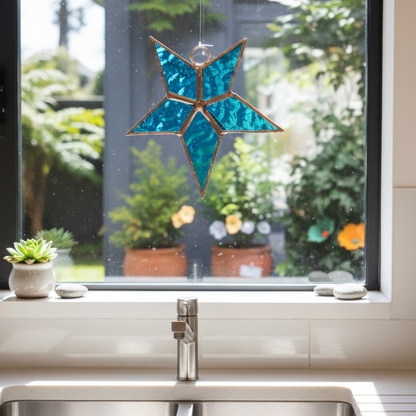 Blue Leadlight Star by Jenni Foster hanging in kitchen window with sunlight shining through turquoise glass
