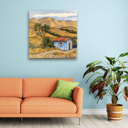 Blue Shed by John Staniford – framed artwork mockup featuring an acrylic New Zealand painting styled in a modern interior