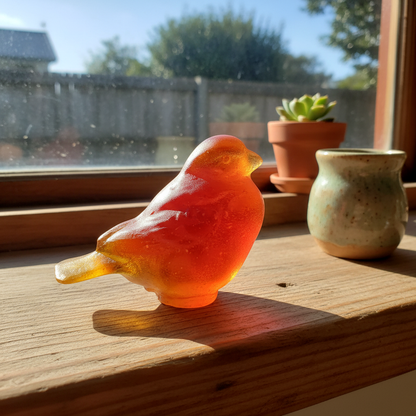 Cast Glass Bird – Orange in a home mock up on the windowsill with light