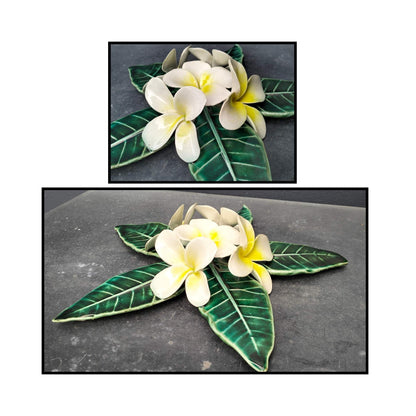 Three-dimensional ceramic Frangipani Wall Hanging by Tom Somerville with white flowers, yellow centers, and glossy green leaves -close ups

