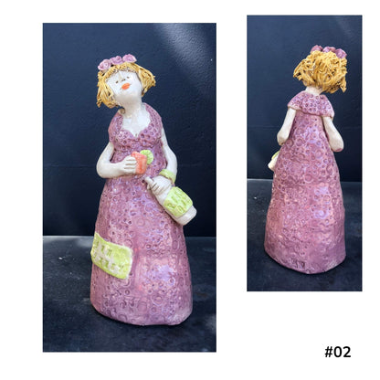 Mandy Olson’s ceramic lady 02, with yellow hair, a purple dress with she is holding a gin glass and a bottle of gin shown from the front and back.