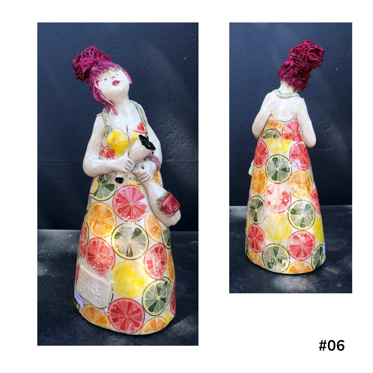 Mandy Olson’s ceramic lady 67, with maroon hair, her dress is orange, lime lices pattern, she is holding a wine glass and a bottle of wine, shown from the front and back.