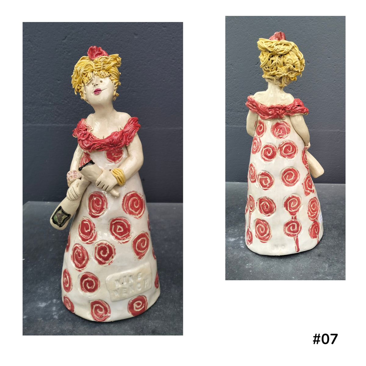 Mandy Olson’s ceramic lady 07, with yellow hair, a white dress with red koru shape pattern, she is holding a wine glass and a bottle of wine, shown from the front and back.
