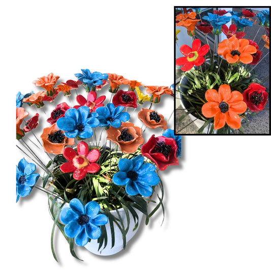 A colorful arrangement of ceramic outdoor flowers in a white vase with blue, red, orange, and yellow blossoms, shown on a white background with a small inset photo of the same arrangement in use.