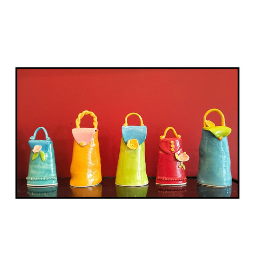 Five colorful ceramic bags with floral decorations on a red background
