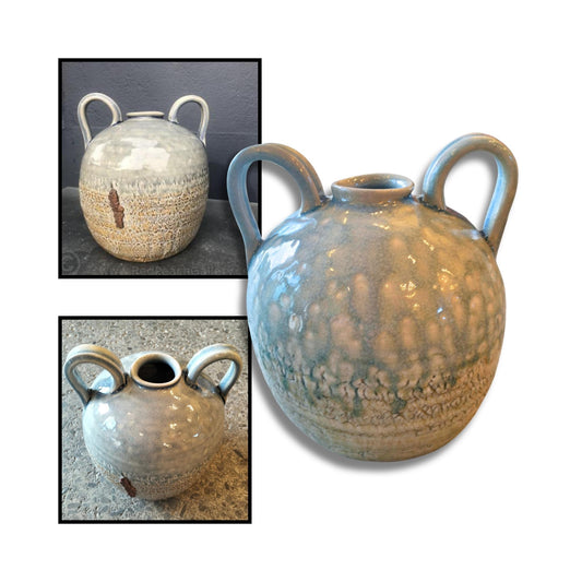 Handmade double handle ceramic jug by Chloe Foster with one side in crackled brown and white texture and the other in smooth grey-blue glaze, displayed against a neutral background.