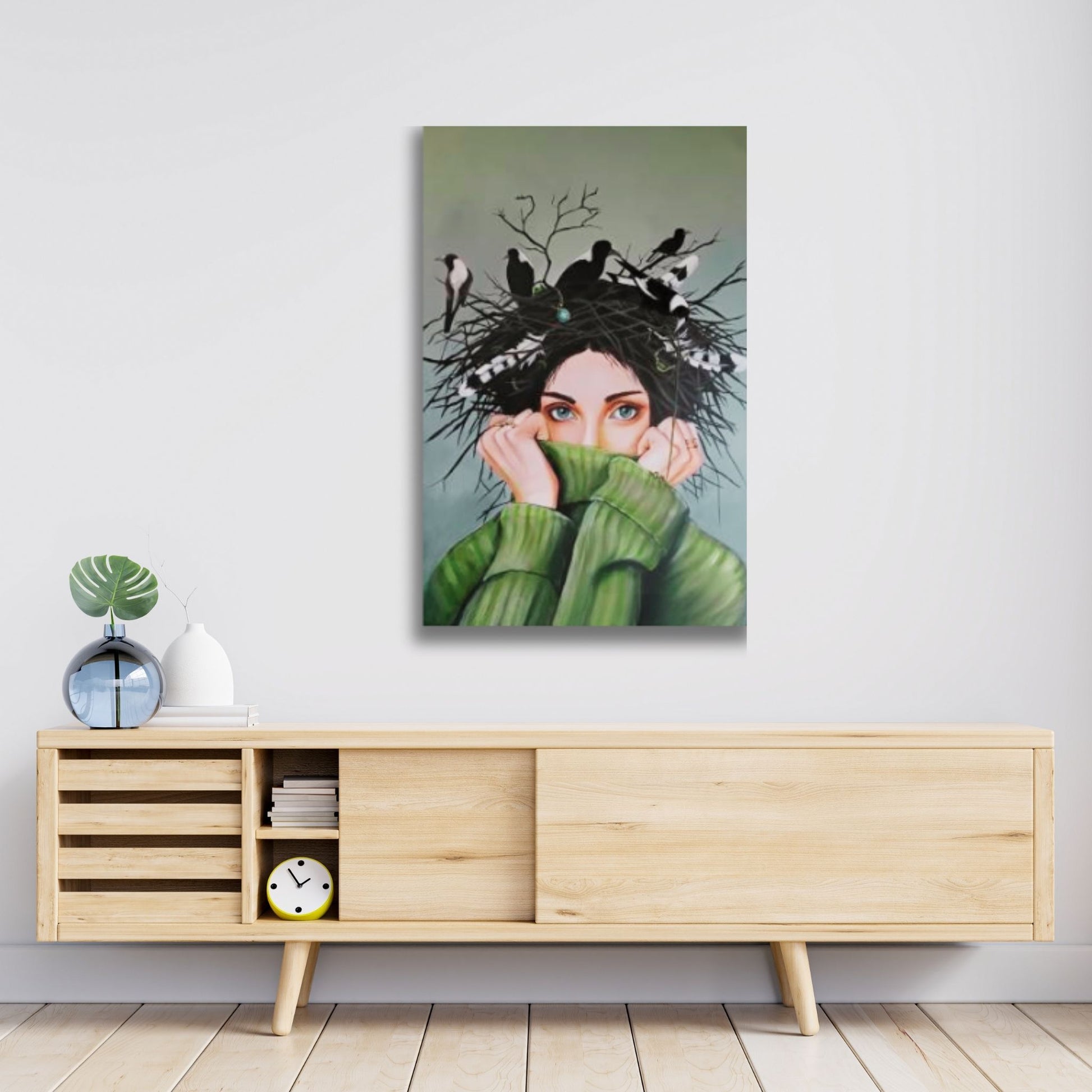 Symbolic painting of a woman with magpies nesting in her hair in a lifestyle mock up, artist Mari Moore
