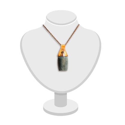 Triangular copper bail on a greenstone pendant by Gary Howse, displayed on a jewellery bust.