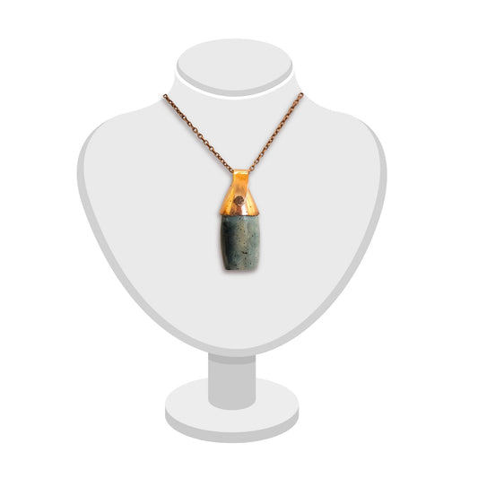 Triangular copper bail on a greenstone pendant by Gary Howse, displayed on a jewellery bust.