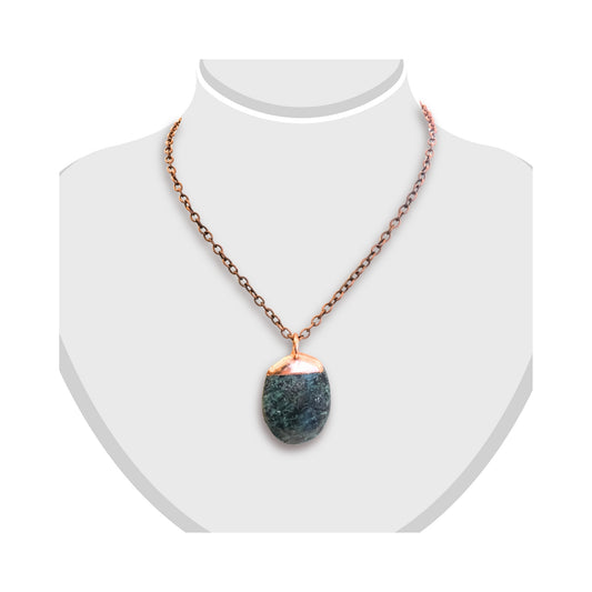 Greenstone pendant capped with smooth copper, displayed on a white bust.