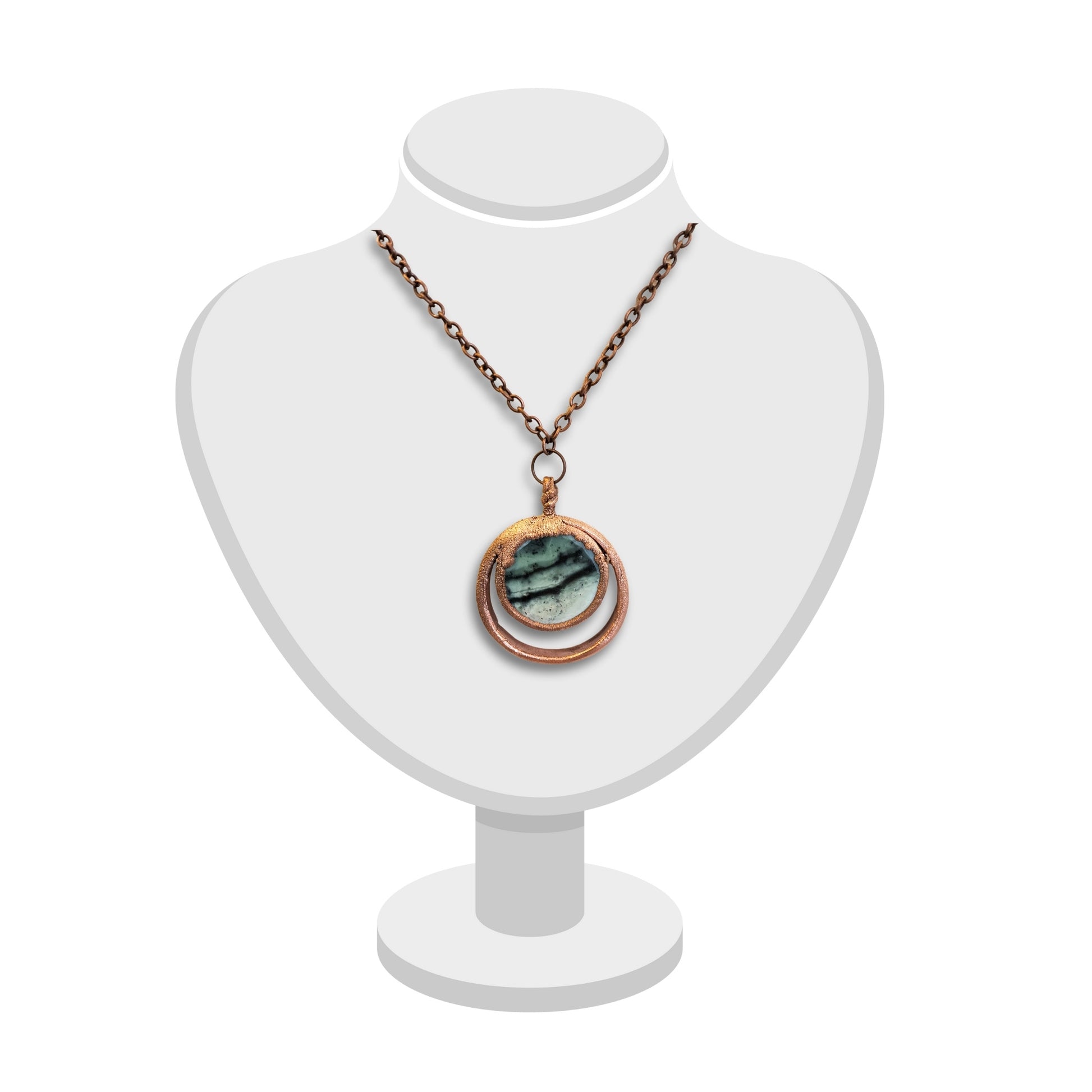 Handmade double loop greenstone pendant with textured copper displayed on white bust.