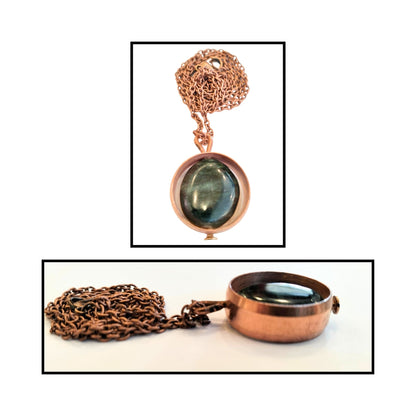 Close-up of oval greenstone bead loosely held inside smooth copper ring.