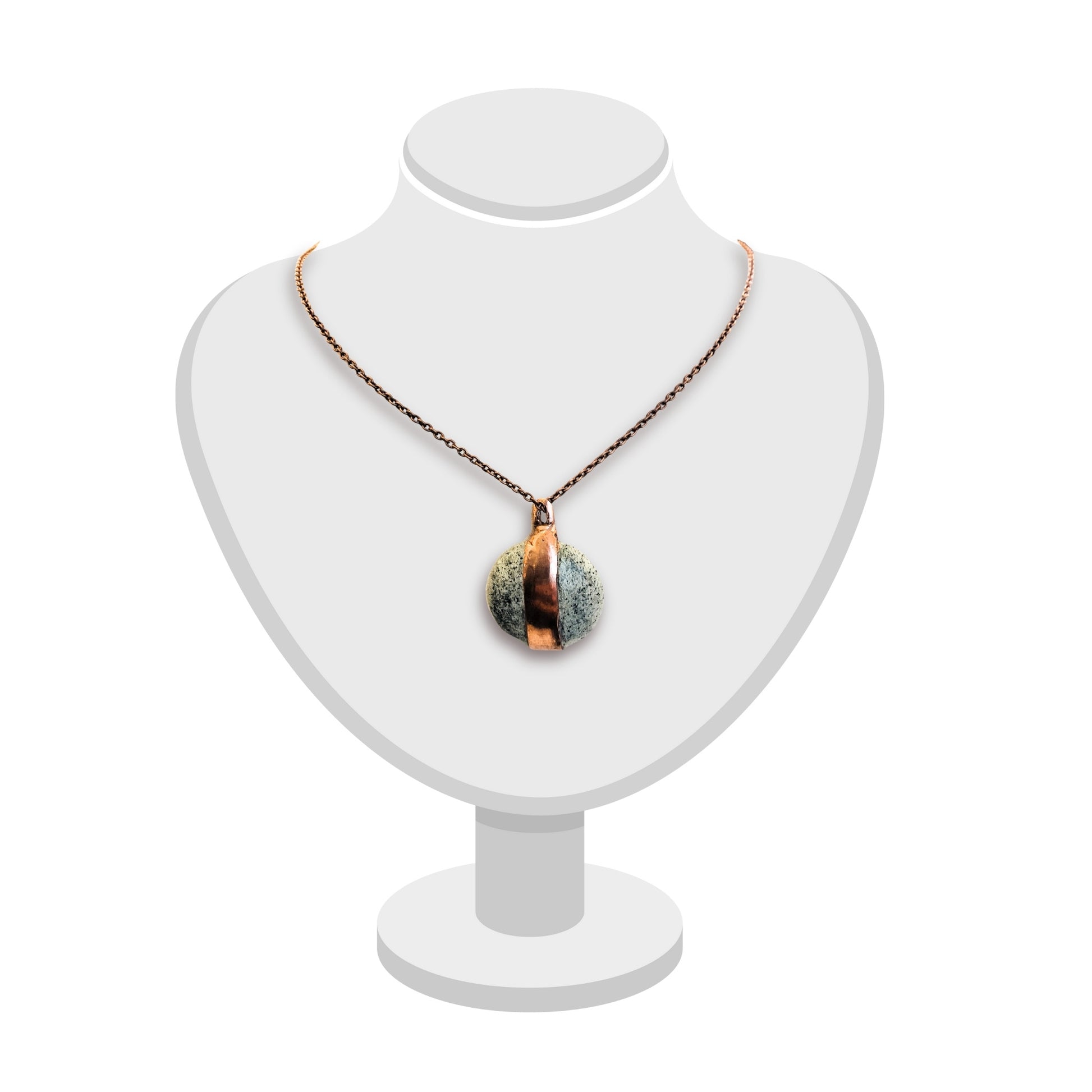 Handcrafted greenstone and copper pendant by Gary Howse displayed on a white bust, showing its organic texture and natural green tones.
