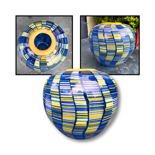 Handblown glass vessel by Heather Kremen with yellow rim and vertical segmented panels in blue and yellow tones.