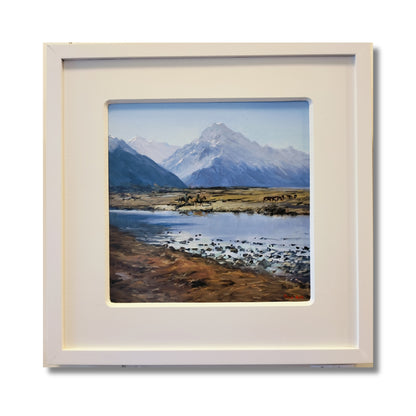 Horseman Tasman Valley, original oil on board by Don Hill, two horsemen mustering cattle below Aoraki Mount Cook with river and tussock flats, white mat and frame

