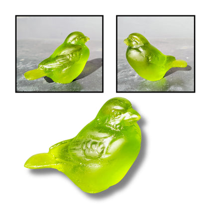 Cast glass bird sculpture in vivid lime green by Lou Mathieson, 7x4x5cm, shown on white background
