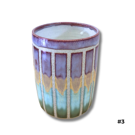 Handmade ceramic vase with purple, gold, and aqua dripping glazes and carved vertical lines by Karene Fairey
