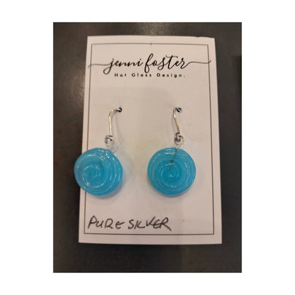 Jenni Foster’s round glass koru earrings in pale blue,  displayed on jewellery card.