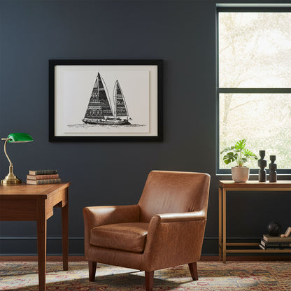 Brown leather armchair in a room with a framed sailboat print on the wall, a desk, and a window.
