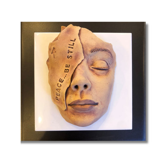 Peace be Still ceramic face on tiles by artist Lyn Rigg on white background