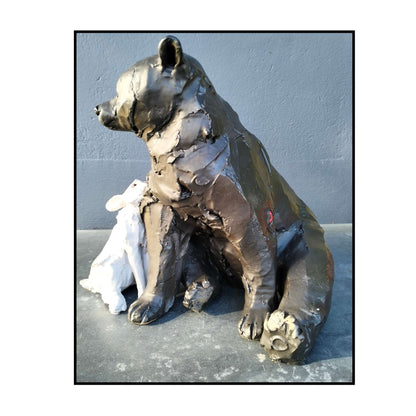 Hand-sculpted ceramic bear and rabbit titled "Secret Crush" by Kylie Matheson – a tender moment captured in clay, full view from right side showing signature red arrow