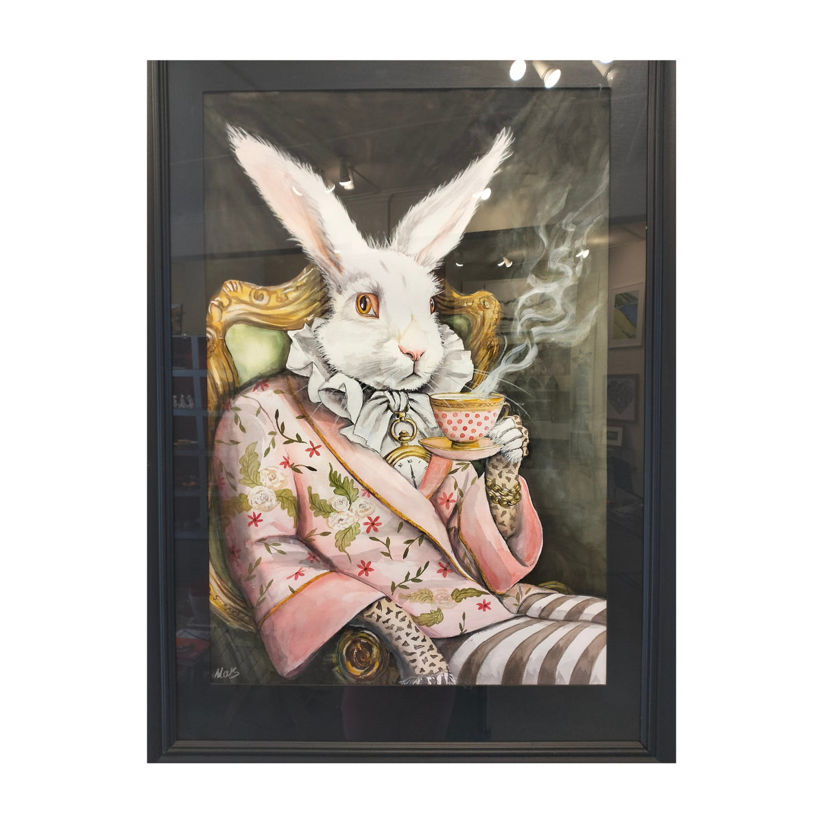 A framed original art, featuring a white rabbit dressed in a pink floral jacket and striped trousers, sitting in an ornate chair and holding a teacup. The artwork is enclosed in a black frame and photographed against a light gray background.