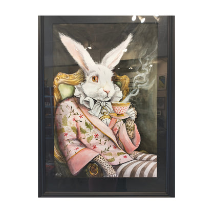 A framed original art, featuring a white rabbit dressed in a pink floral jacket and striped trousers, sitting in an ornate chair and holding a teacup. The artwork is enclosed in a black frame and photographed against a light gray background.