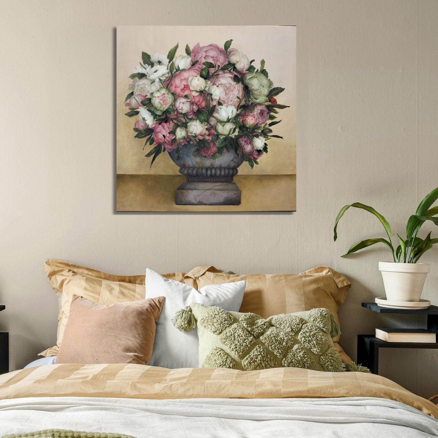 Floral painting above a bed with decorative pillows and a plant.