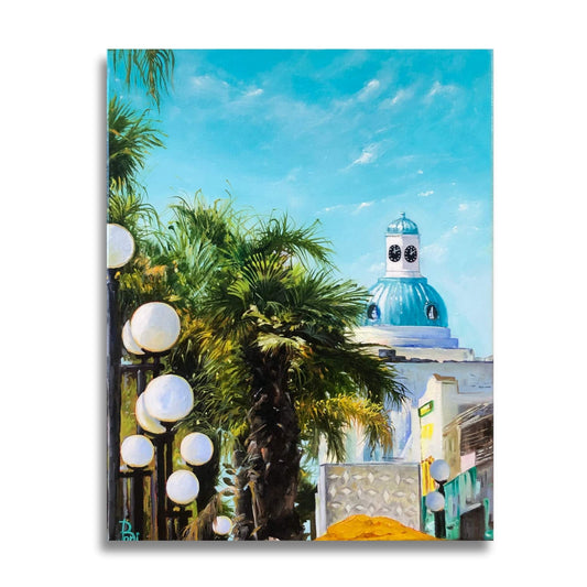 Painting of sunny Napeir the 
Art Deco capital of the world.  Scene includes  palm trees, street lights, and a building with a blue dome with a clock tower.