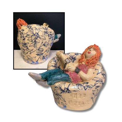 Close-up of Wine O'Clock ceramic sculpture  A, showing intricate hand-painted details and whimsical character holding wine glass